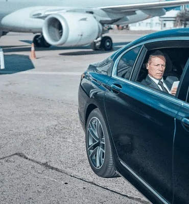 Chauffeur greeting client at the airport terminal with a name sign