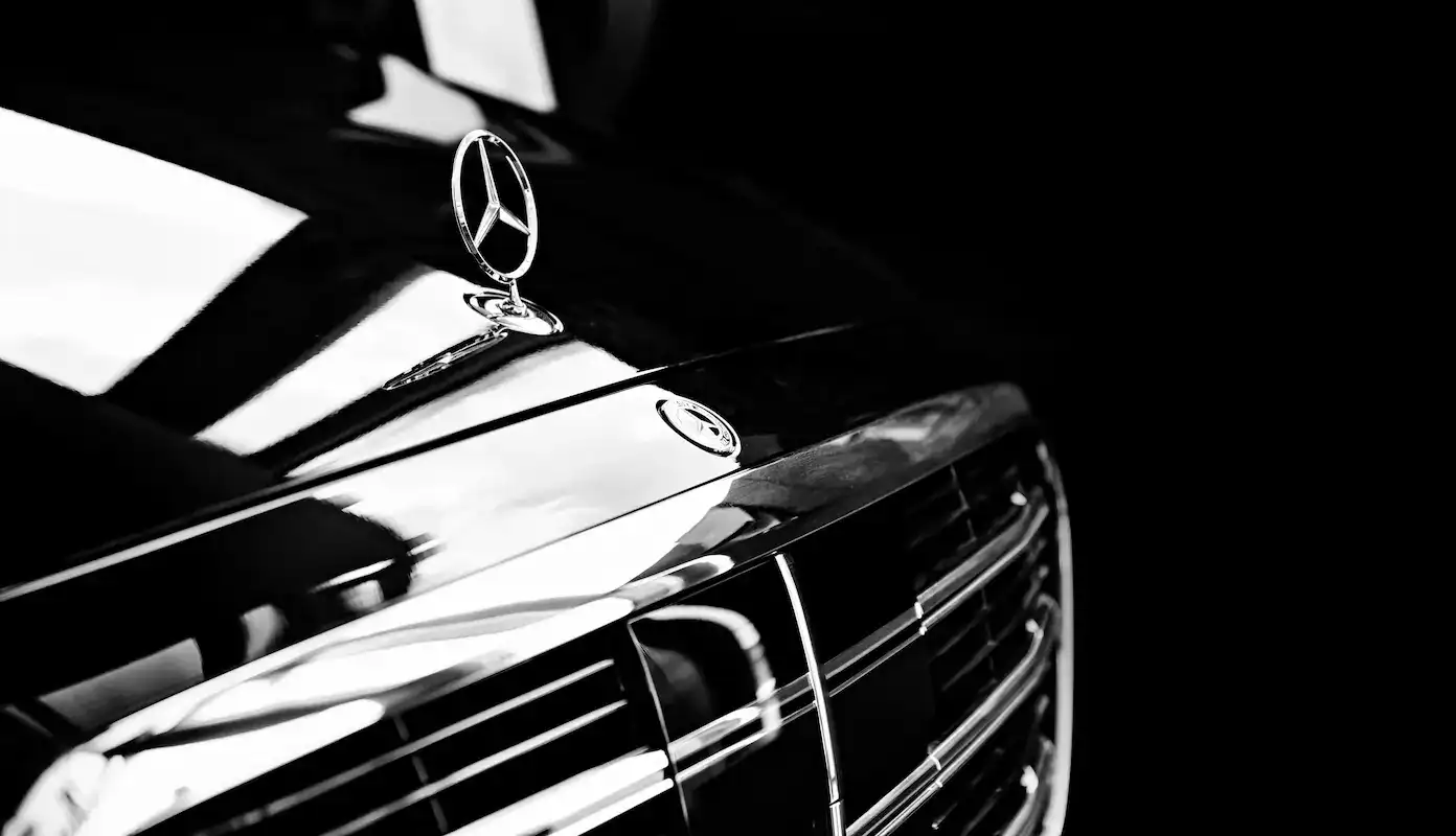 Mercedes S-Class black sedan parked at luxury hotel entrance