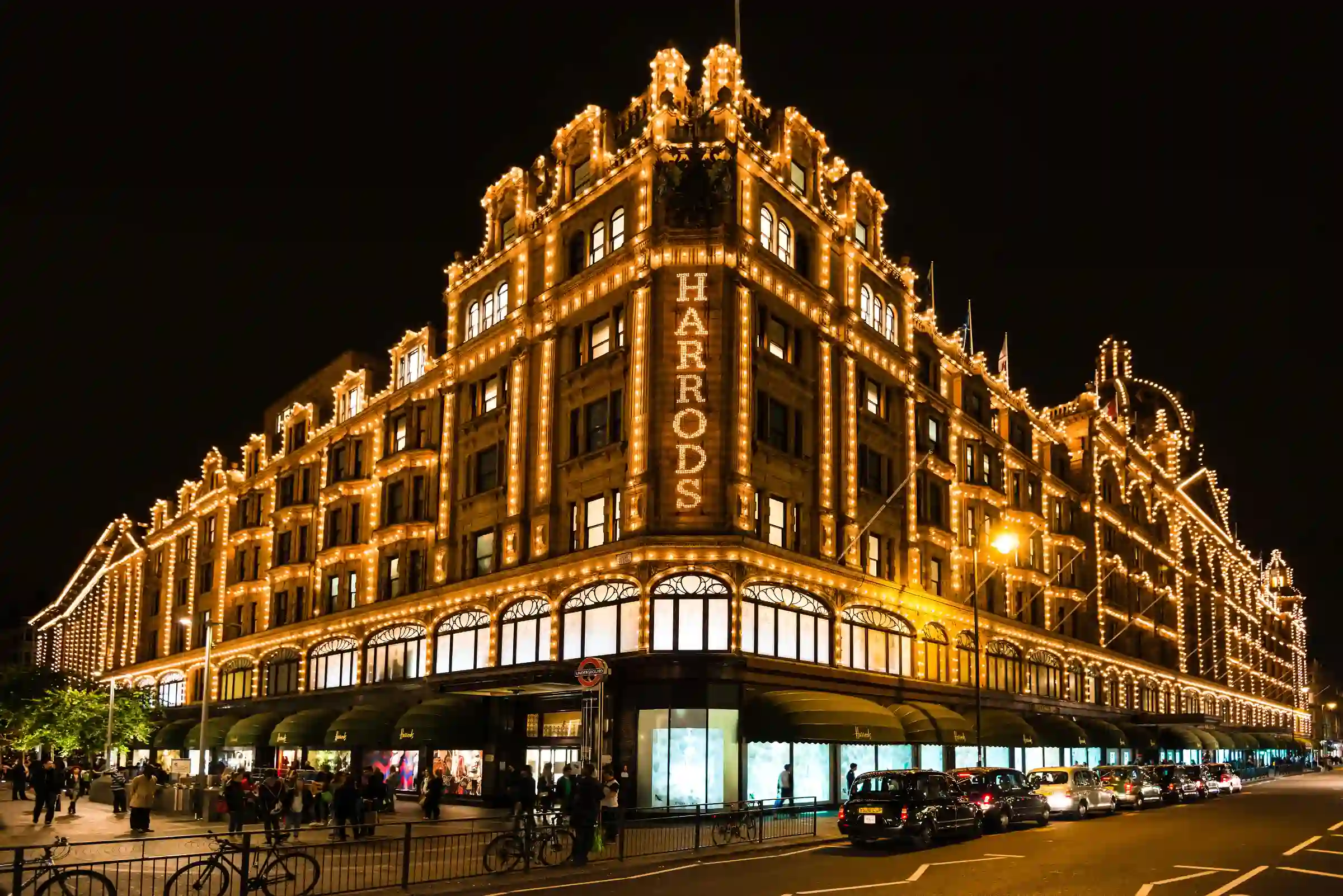 Harrods Knightsbridge illuminated by night — London luxury shopping district