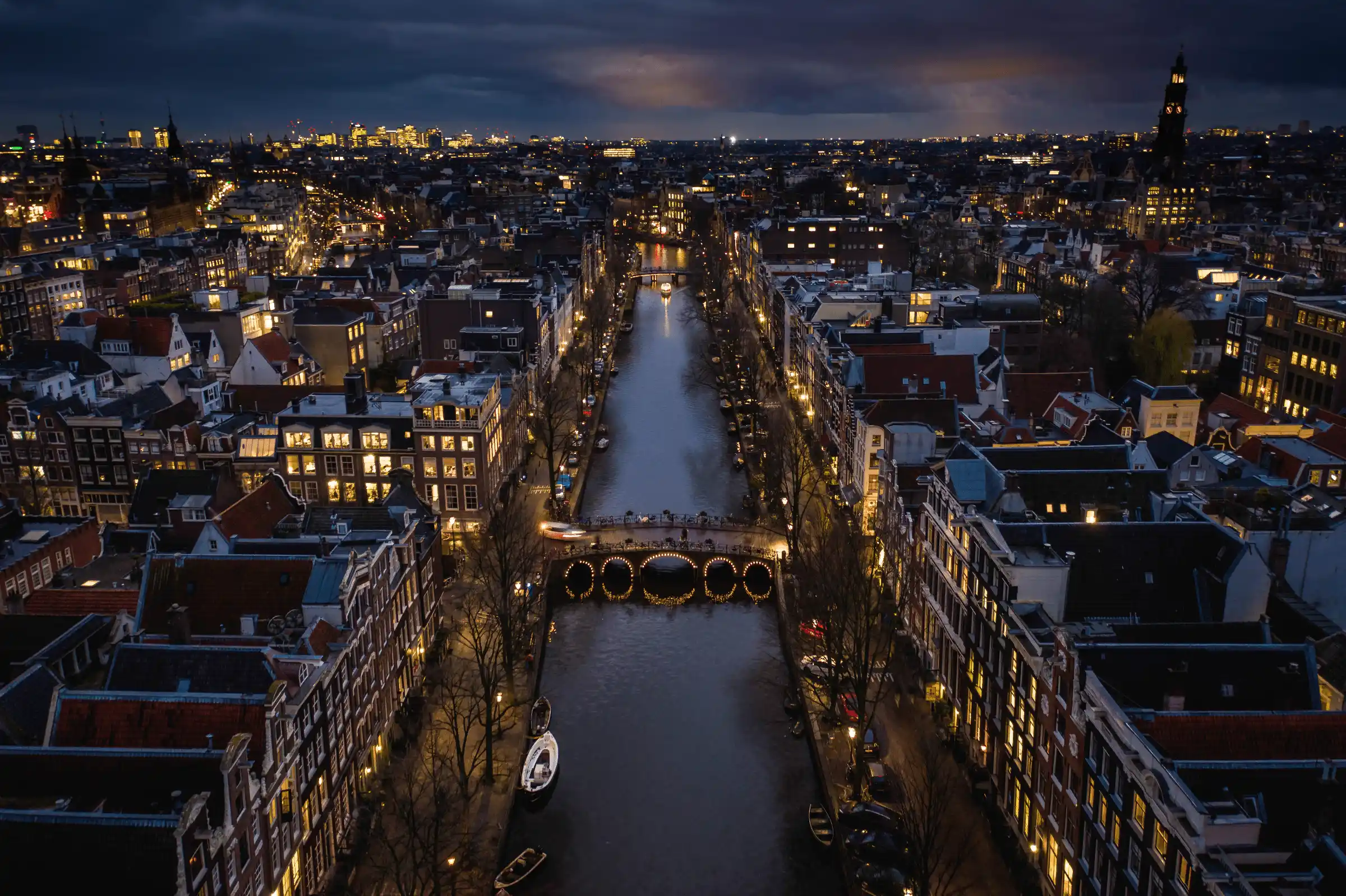 Luxury private chauffeur service in Amsterdam — canal houses skyline at night