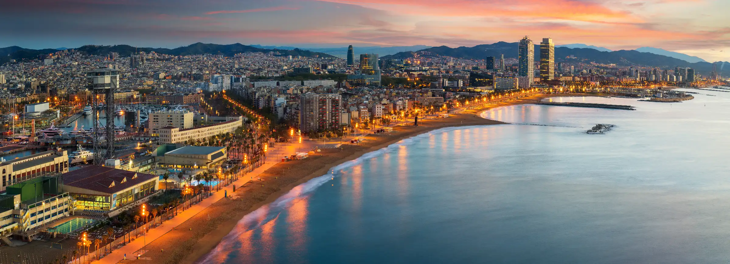 Luxury private chauffeur service in Barcelona — Barceloneta beach skyline at sunset