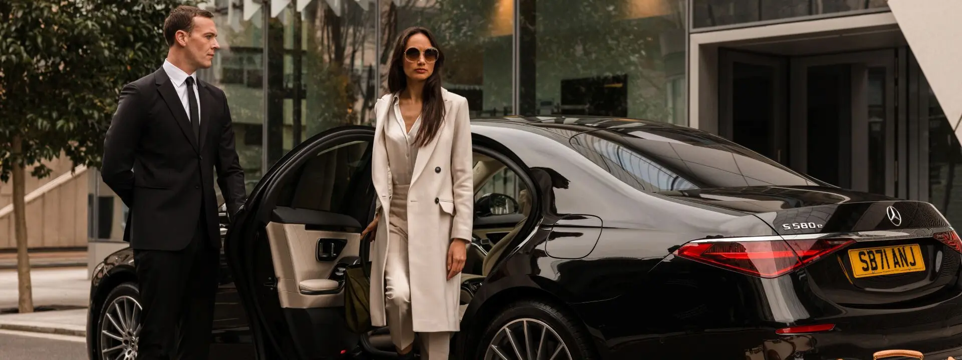 Professional driver opening Mercedes door for a client